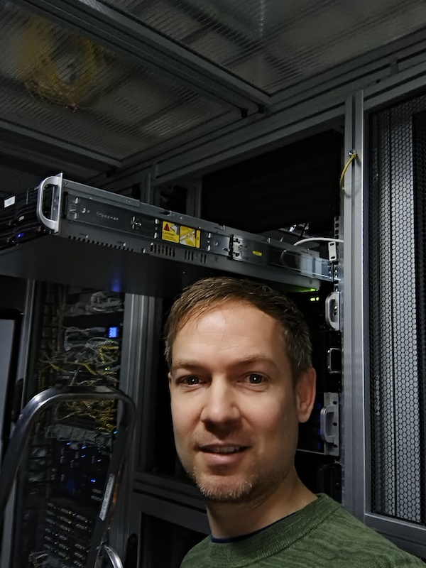 IT-Blaschke steht vor einem teilweise eingebauten Server in einem Rechenzentrum und lächelt in die Kamera. IT-Blaschke steht vor einem teilweise eingebauten Server in einem Rechenzentrum und lächelt in die Kamera.